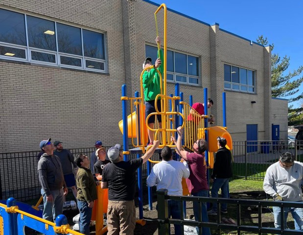 A team of volunteers and parents help assemble the new playground at St. Germaine Catholic School in Oak Lawn, which officially opened Wednesday. (St. Germaine)