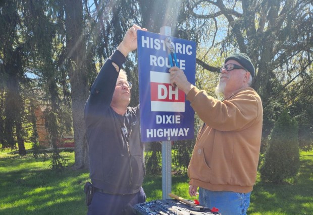 Phil Serviss, left, and John Maracic, members of the A's-R-Us Model A Ford club based in Crete, erect a new Dixie Highway sign in April along the route of the historic road in Crete. June's Day on the Dixie tour will raise money for maintenance and more signs along the route, Serviss said. (Phil Serviss)