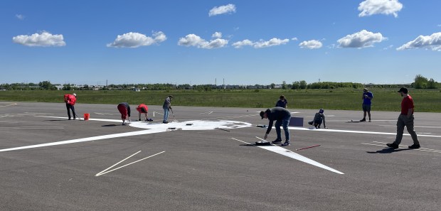 The first crew of volunteers work on the rose compass project May 11, 2024, at the Lansing Municipal Airport. (Jeff Vorva/for Daily Southtown)