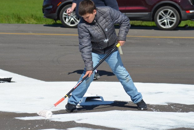 DeKalb sixth grader Jack Wild made the trip to Lansing to paint the rose compass at the Lansing Municipal Airport. (Jeff Vorva/for Daily Southtown)