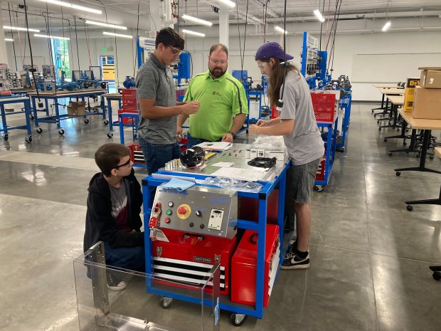 Students in the College of Lake County Advanced Technology Center learn to mount a motor.