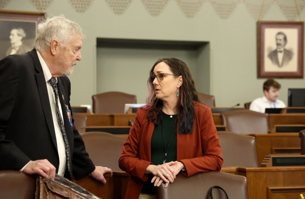 State Rep. Kelly Cassidy, right, chats with state Rep. Steve Reick before the start of a committee meeting in the Capitol on Feb. 7, 2024, in Springfield. Cassidy is the main House sponsor of the bill on Prisoner Review Board changes. (Stacey Wescott/Chicago Tribune)