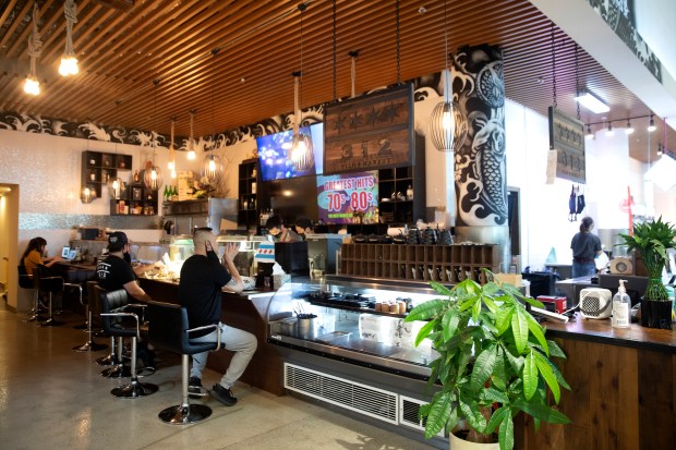 People sit at the 312 Fish Market sushi bar at 88 Marketplace on June 30, 2021. 88 Marketplace is a highly popular grocery store with several different food stalls. (Erin Hooley/Chicago Tribune)