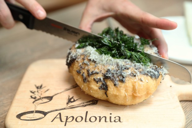 Chef/owner Stephen Gillanders cuts into a loaf of black truffle puff bread at Apolonia on June 17, 2021, in Chicago. (John J. Kim/Chicago Tribune)