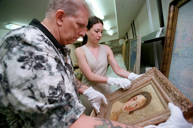 Gerald McDonald, left, and Michaela Hajkova, curator of the Jewish Museum in Prague, look over the painting "Head of a young woman" by Andre Derain on July 1, 2002. (John Smierciak/Chicago Tribune)