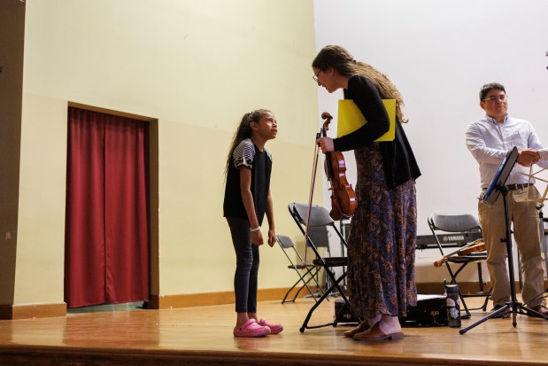 Civic Orchestra of Chicago musician Lina Yamin, right, from Venezuela, speaks with a child after members of the Civic Orchestra of Chicago performed in a shelter at the American Islamic College on Memorial Day, Monday May 27, 2024, in Chicago. (Armando L. Sanchez/Chicago Tribune)