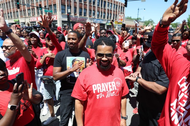 The Rev. John Hannah of New Life Covenant Church Southeast, center, gathers with church members and area residents at the corner of East 79th Street and South Cottage Grove Avenue during the "Prayer on the 9" march against violence on May 25, 2024, in Chicago. (John J. Kim/Chicago Tribune)