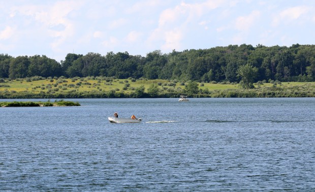 Anglers ride on a boat through Shabbona Lake at Shabbona Lake State Park on July 27, 2022. Much of the land in the area was owned by the Potawatomi Nation and Chief Shab-eh-nay. (John J. Kim/Chicago Tribune)