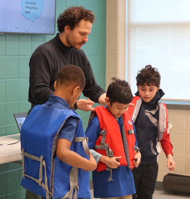 Tony Strack helps swim students with life jackets. (Photo courtesy of Waukegan Park District)