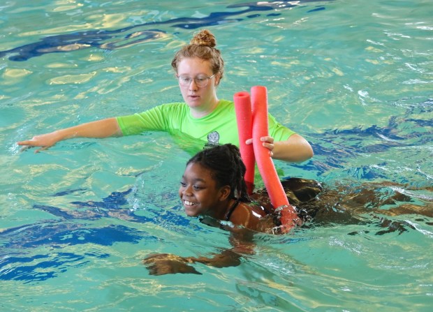 An swim teacher supports a student as she learns how to swim. (Photo courtesy of Waukegan Park District)