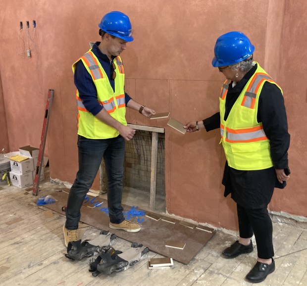 Lori Nerheim and Ty Rohrer talk about the restored original tiles which will go around the fireplace in the Ray Bradbury Room at the Waukegan History Museum at the Carnegie. The paint is a precise replica of the original. (Steve Sadin/Lake County News-Sun)