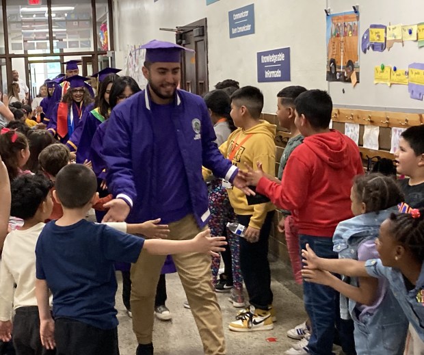 Waukegan High School seniors ready for graduation are greeted by students at Whittier Elementary School as part of the Return to My Roots event. (Steve Sadin/Lake County News-Sun)