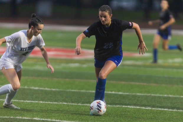 St. Charles North's Kaitlin Glenn (25) advances the ball past New Trier's Kennedy Colegrove (2) in the Class 3A championship game, at North Central College in Naperville on Saturday, June 1, 2024. (Vincent D. Johnson/for the Beacon-News)