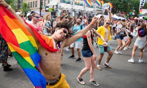 Festival-goer Jose Ojeda dances with a rainbow flag around his neck during Chicago Pride Fest on June 17, 2018, in Chicago. (Courtney Pedroza/Chicago Tribune)