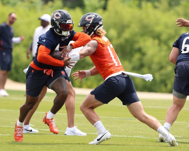 Chicago Bears quarterback Tyson Bagent (17) hands off to wide receiver DJ Moore (2) during minicamp at Halas Hall on June 4, 2024, in Lake Forest. (Stacey Wescott/Chicago Tribune)