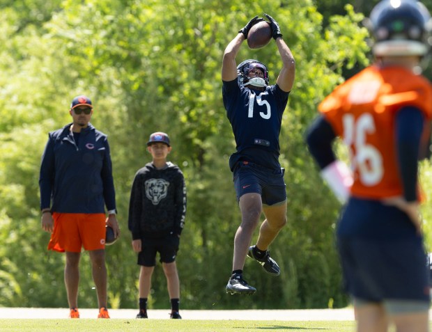 Bears wide receiver Rome Odunze catches a pass while GM Ryan Poles and his son, Mason, watch him from the sidelines during minicamp at Halas Hall on June 6, 2024. (Stacey Wescott/Chicago Tribune)