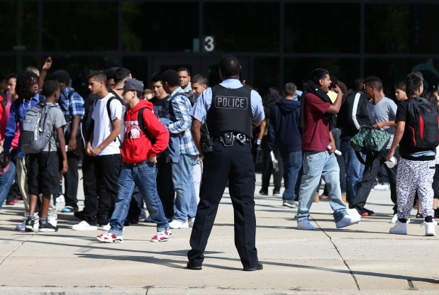 A Chicago police officer observes dismissal at the end of the school day at Roberto Clemente High School on Sept. 14, 2015. (Terrence Antonio James/Chicago Tribune)