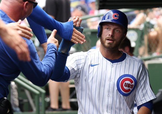 Cubs first baseman Michael Busch is congratulated after scoring on a single by Seiya Suzuki in the first inning against the Mets on June 22, 2024, at Wrigley Field. (John J. Kim/Chicago Tribune)