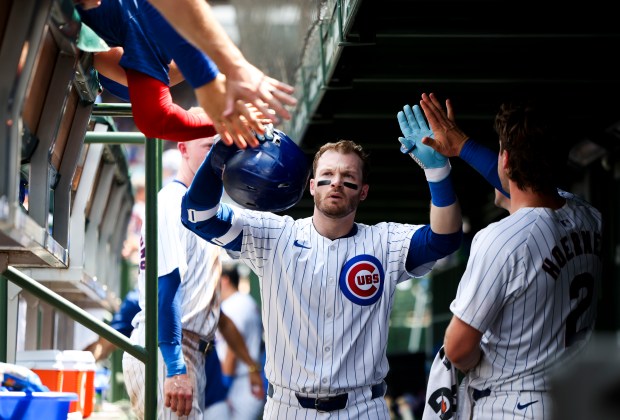 Cubs left fielder Ian Happ gets high-fives from teammates after hitting a home run in the fourth inning against the San Francisco Giants on June 19, 2024, at Wrigley Field. (Eileen T. Meslar/Chicago Tribune)