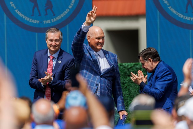 Former Cubs player Ryne Sandberg, center, stands next to Cubs Chairman Tom Ricketts, left, and sports broadcaster Bob Costas, right, while attending a dedication ceremony for his statue outside Wrigley Field Sunday June 23, 2024 in Chicago. (Armando L. Sanchez/Chicago Tribune)