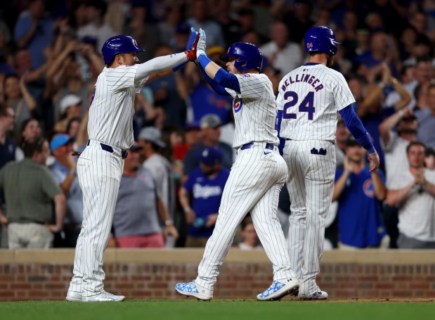 Chicago Cubs outfielder Ian Happ (8), center, high-fives outfielder Seiya Suzuki (27) after hitting a three-run homer in the bottom of the seventh inning during a game against the San Francisco Giants at Wrigley Field on June 17, 2024, in Chicago. Happ's homer put the Cubs ahead 6-3 but the lead did not hold. The Giants beat the Cubs 7-6. (Stacey Wescott/Chicago Tribune)