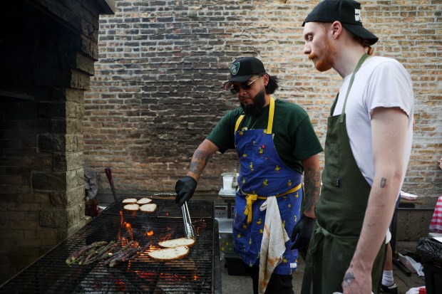 Le Bouchon sous-chef Jose Molina, left, and line cook Kurtis Kincaid grill during a Sunday BBQ on the patio of Sportsman's Club in Ukrainian Village on June 2, 2024. (Eileen T. Meslar/Chicago Tribune)