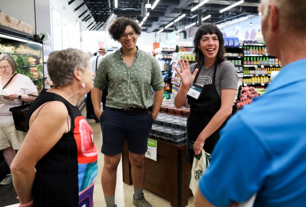 General manager Teresa Meza, second from right, and shopper Thistle Van Dyk, second from left, speaks to owners Annalee Letchinger, left, and David Hoppe at Wild Onion Market co-op during the grand opening in Rogers Park on June 12, 2024. (Eileen T. Meslar/Chicago Tribune)