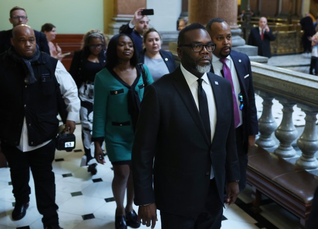 Mayor Brandon Johnson, foreground, walks to the office of Senate President Don Harmon for a meeting at the Illinois State Capitol, May 8, 2024. (John J. Kim/Chicago Tribune)