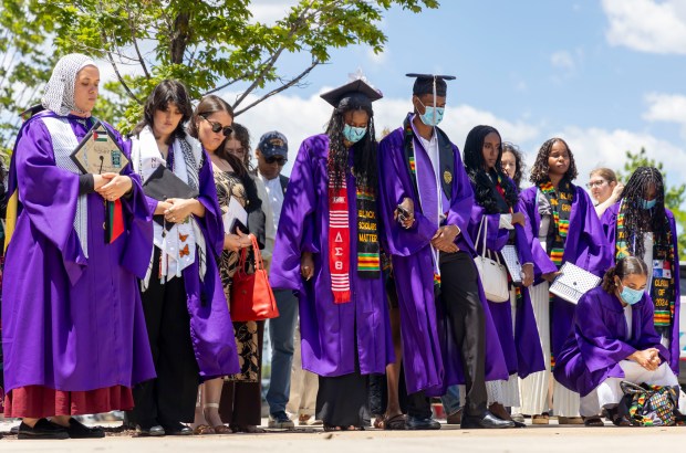 Several dozen graduates and supporters take a moment of silence for Palestinian victims of the war in Gaza after walking out in protest during Northwestern University's commencement on June 9, 2024, at the United Center. (Brian Cassella/Chicago Tribune)