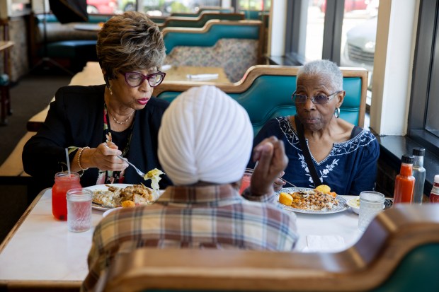 Jackie White, left, Marva Watts, and Anna West, eat together on June 7, 2024, at St. Rest #2 Country Kitchen in Chicago. (Vincent Alban/Chicago Tribune)