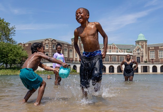 Karter Vaughters, 4, splashes his brother Joshua, 9, while they play at Humboldt Park Beach on Sunday, June 16, 2024, with temperatures over 90 degrees. Chicago's only inland beach officially reopens Monday after a four-year closure. (Brian Cassella/Chicago Tribune)