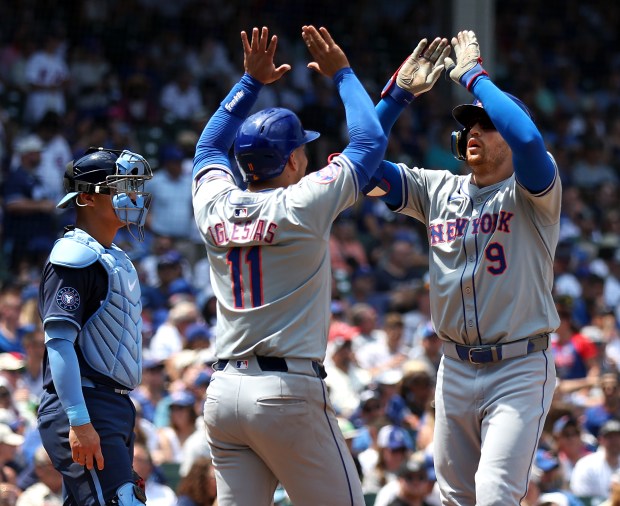 New York Mets left fielder Brandon Nimmo (9) celebrates with teammate Jose Iglesias (11) after Nimmo hit a 2-run home run in the second inning of a game against the Chicago Cubs at Wrigley Field in Chicago on June 21, 2024. (Chris Sweda/Chicago Tribune)
