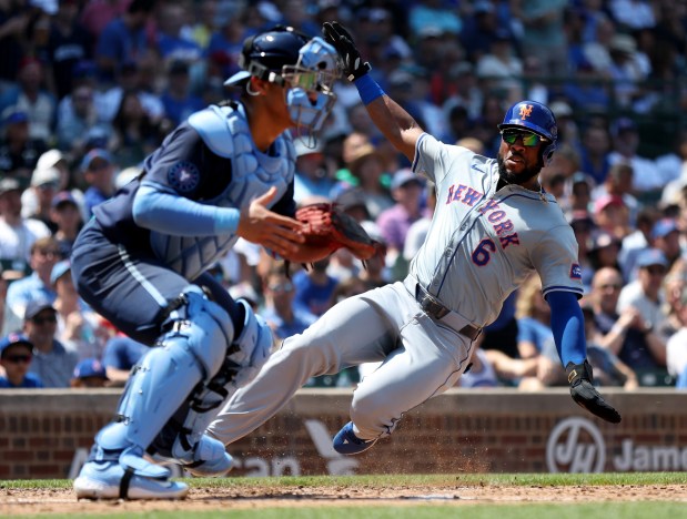 New York Mets right fielder Starling Marte (6) slides in safely at home plate to score on a 2-run single by teammate Jose Iglesias in the fourth inning of a game against the Chicago Cubs at Wrigley Field in Chicago on June 21, 2024. (Chris Sweda/Chicago Tribune)