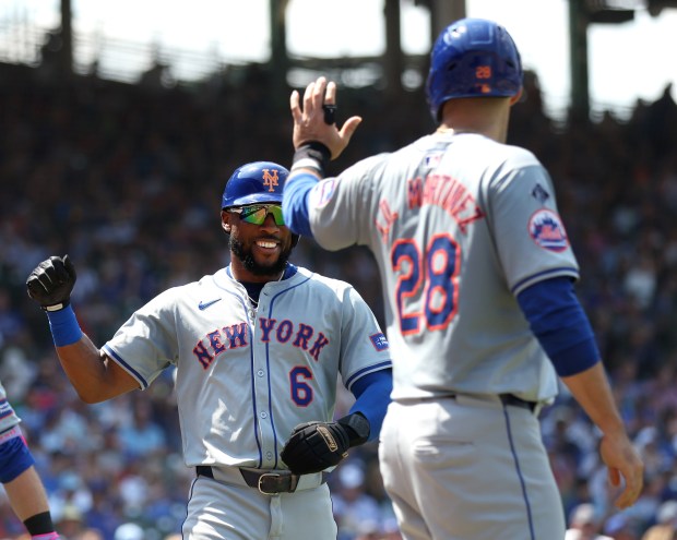 New York Mets right fielder Starling Marte (6) is congratulated by teammate J.D. Martinez (28) after Marie scored on a 2-run single by Jose Iglesias in the fourth inning of a game against the Chicago Cubs at Wrigley Field in Chicago on June 21, 2024. (Chris Sweda/Chicago Tribune)