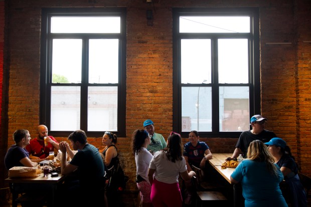 Guests socialize during the soft opening for Monochrome Brewing on May 1, 2024, in Pilsen. (Vincent Alban/Chicago Tribune)