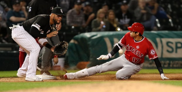 Chicago White Sox third baseman Yoan Moncada (10) waits for the ball as Los Angeles Angels designated hitter Shohei Ohtani slides safely into third base after his triple in the seventh inning of a game at Guaranteed Rate Field in Chicago on Friday, Sept. 6, 2019. (Chris Sweda/Chicago Tribune)