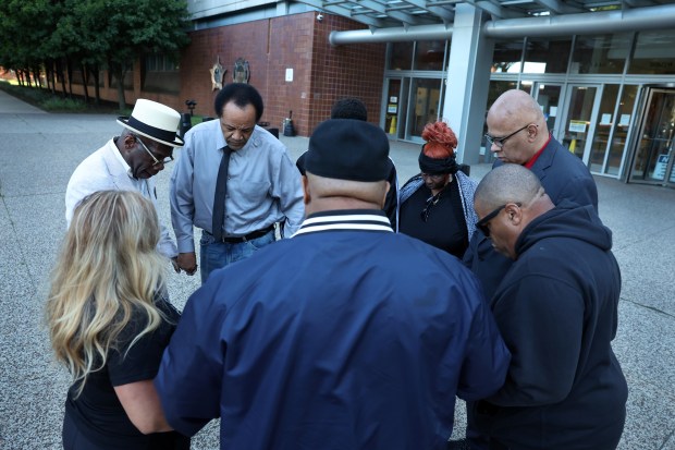 Community activists and violence interrupters pray together before holding a press conference in front of Chicago police headquarters in response to a Memorial Day weekend shooting that resulted in the death of 5-year-old Reign Ware. (Chris Sweda/Chicago Tribune)