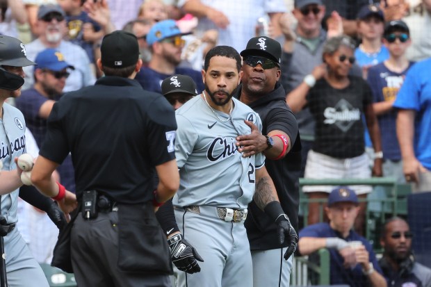 White Sox outfielder Tommy Pham is restrained by coaches during the eighth inning against the Brewers on June 2, 2024, in Milwaukee. (Stacy Revere/Getty)