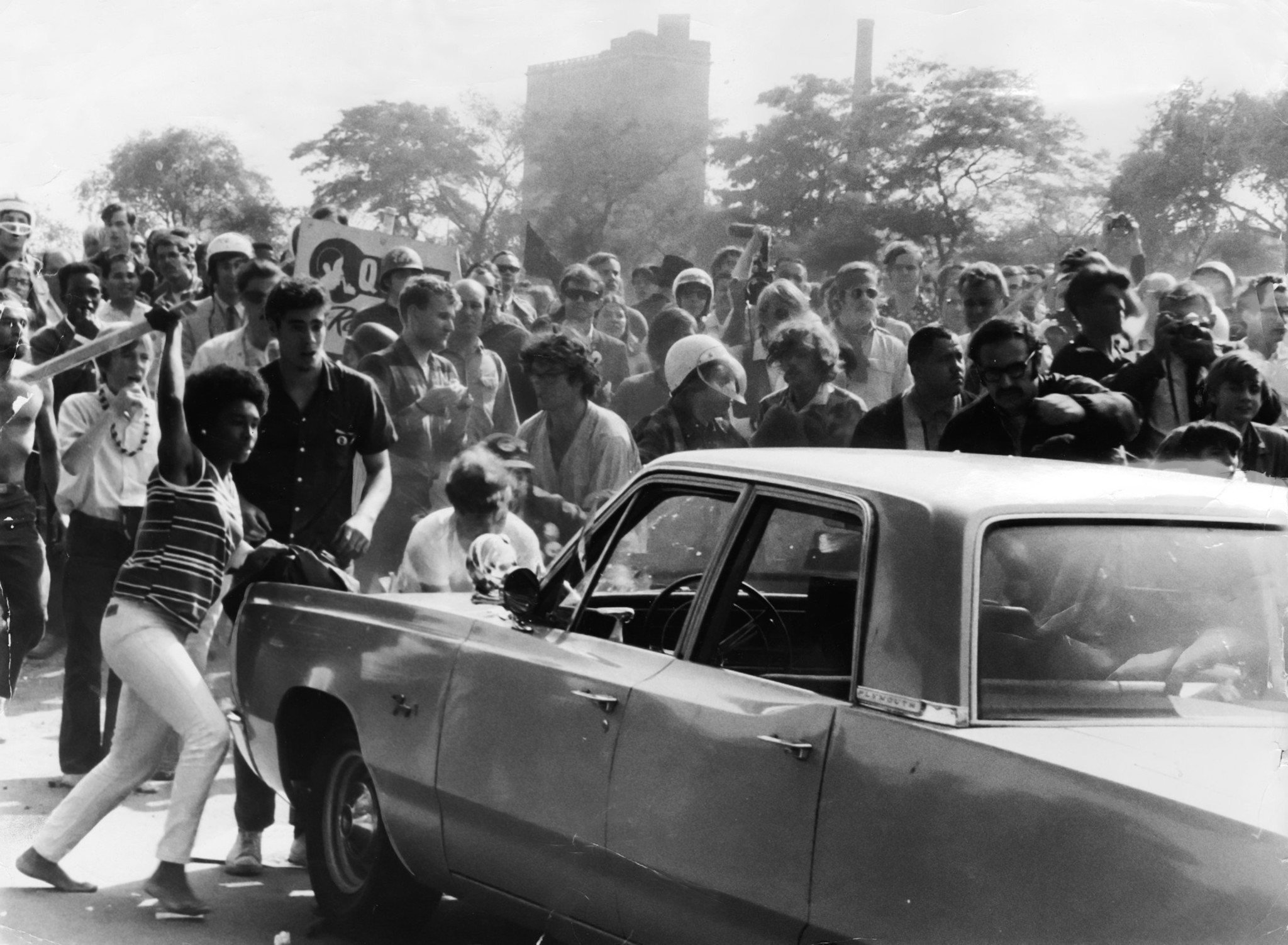 Wielding a club, a protester joins others in an attack...