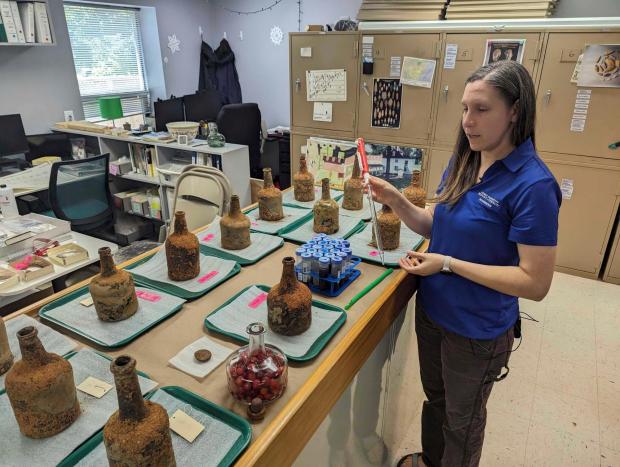 Curator Lily Carhart shows a pipette they used to extract liquid from a few dozen 18th-century glass bottles that contained fruit after they were unearthed from the cellar of George Washington's residence in Mount Vernon, Va., Monday, June 17, 2024. (AP Photo/Nathan Ellgren)