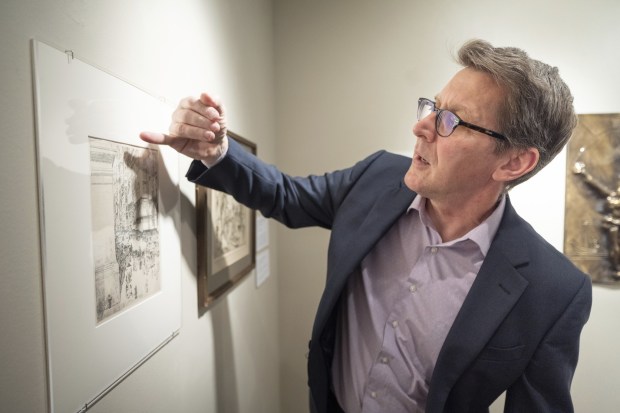 Brauer Museum of Art director and curator Jonathan Canning points out a tear caused when someone tried to steal the piece "Fifth Avenue, Noon", as he points out criteria for deaccessioning art in an exhibit at the museum on Thursday, April 6, 2023. (Kyle Telechan for the Post-Tribune)