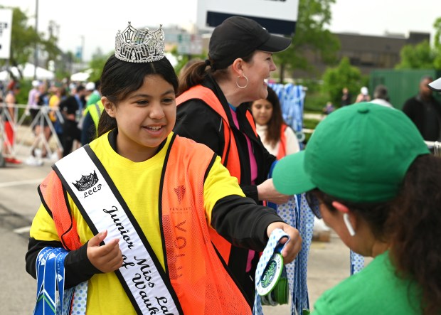 Left, handing out medals at the finish line is Junior Miss Lake County of Waukegan 2024 Melanie Mateos, 11, a fifth-grader of Waukegan, at the Highland Park Run Half Marathon, 5K and 1 Mile Run on June 2, 2024 in downtown Highland Park. (Karie Angell Luc/Lake County News-Sun)