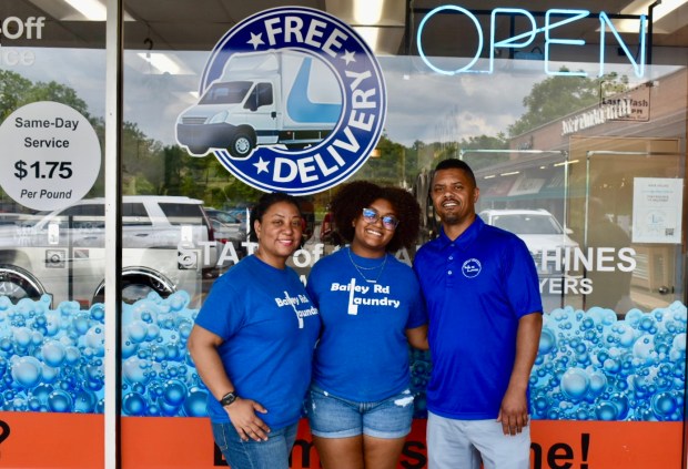 Natalie Fleming, center, helps out at Bailey Rd Laundromat, the Naperville business owned by her parents, Nick and Nicole. (Steve Metsch - Naperville Sun)