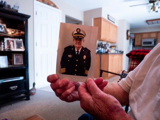 Former Naperville Fire Chief Alan Rohlfs shows a picture of himself wearing his old uniform in May 2024. (Tess Kenny/Naperville Sun)