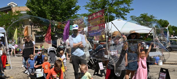 Lower right, Brylene Hsu, 6, of Schaumburg, creates an oversized bubble at the Barrington Art Festival in downtown Barrington on May 25, 2024.