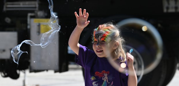 Laila Pinter of Barrington, 5, a kindergartner pops an oversized bubble at the Barrington Art Festival in downtown Barrington on May 25, 2024.