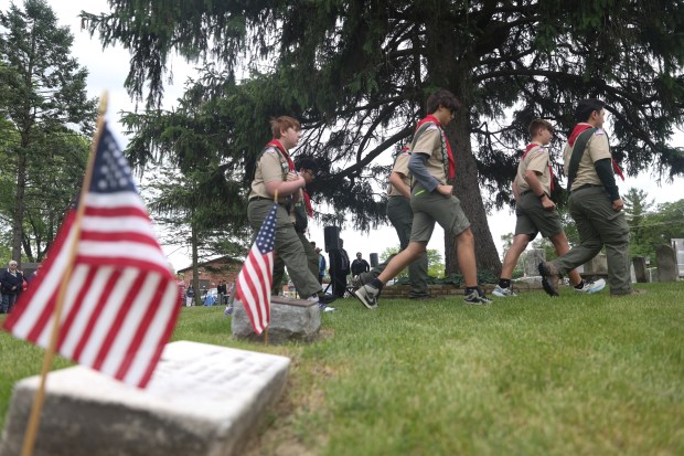 Members of Scout Troop 401 march to a flagpole to lower an American flag during a Memorial Day ceremony at Knopf Cemetery in Buffalo Grove on Monday, May 27, 2024. (Trent Sprague/for the Pioneer Press)