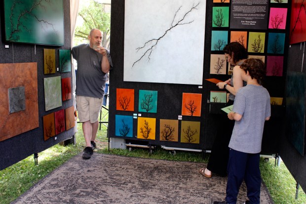 Evanston-based artist Eric Beauchamp shared his work, which he calls High Voltage Pyrography, during Art in the Village sponsored by the North Shore Art League in Hubbard Woods Park this weekend. His art making process explores the intersection of nature, heat, wood and image. (Gina Grillo/Pioneer Press)