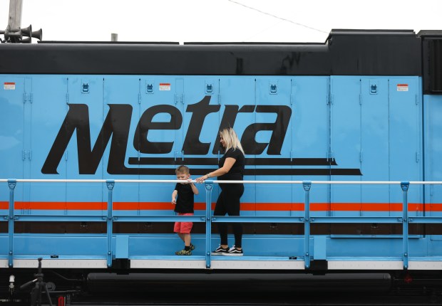 A mother and child walk along the catwalk on the outside of a Metra train engine during Railroad Day at the Franklin Park Festival in Franklin Park on June 8, 2024. (Trent Sprague/for the Pioneer Press)