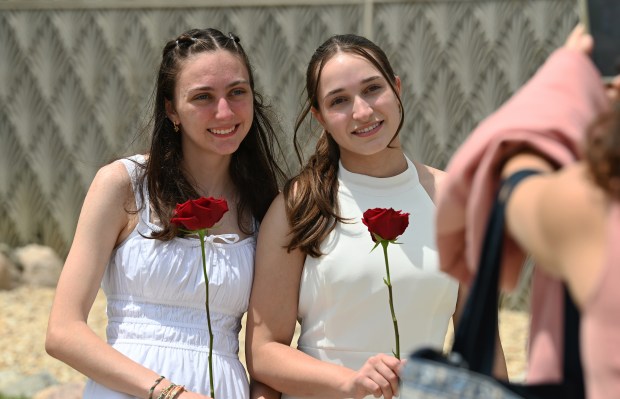 From left to right, Nora Niehus of Glenview and Claire Porwancher of Wilmette have just selected their roses and pose for a photo outside before the 124th annual New Trier Township High School commencement on June 2, 2024 at NOW Arena in Hoffman Estates. (Karie Angell Luc/Pioneer Press)